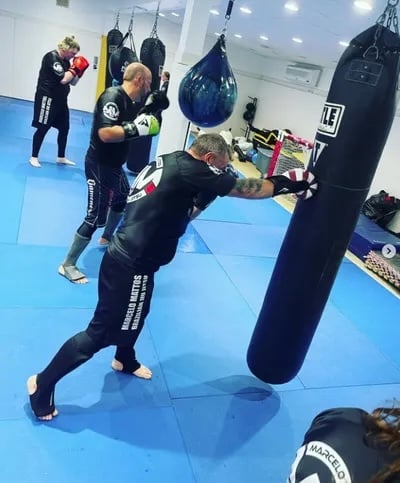 Tiger Shark BJJ Adult Kickboxing Class students practicing with punching bag